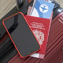 mobile device and passport on luggage